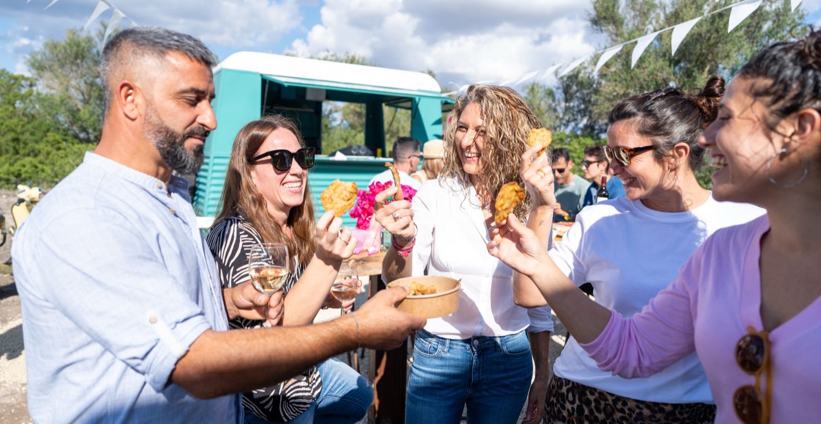 Group of people at an outdoor event, sharing food.